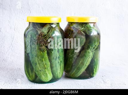 Pickled cucumbers in glass jars with lids Stock Photo