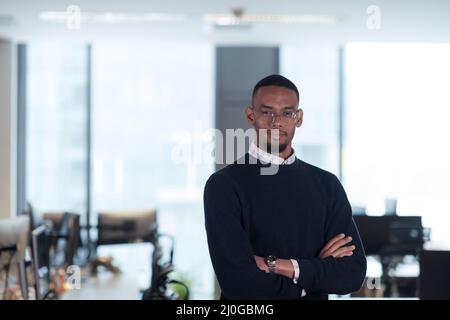 African American man looking at camera standing in office lobby hall. Multicultural company managers team portrait. Stock Photo
