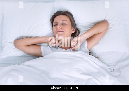 Good morning. Woman wakening up happy in the bed Stock Photo