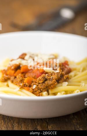 Maccheroni with bolognaise sauce on wood Stock Photo