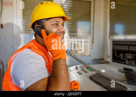 Smiling young construction specialist working in plant Stock Photo