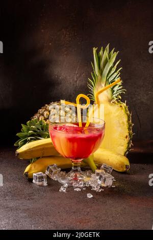 Delicious cold refreshing ananas smoothie drink with banana and redcurrant served in cocktail glass Stock Photo