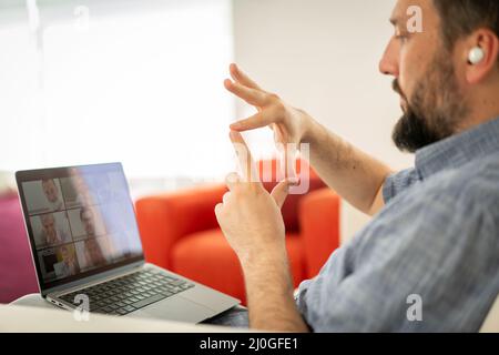 Mid adult man having online conference working from home Stock Photo