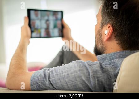 Mid adult man having online conference working from home Stock Photo