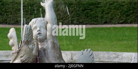 Fountain with figures and water jet in portrait format Stock Photo