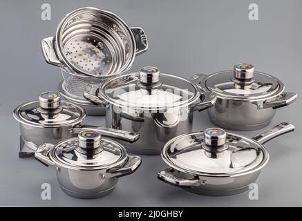 Stainless steel cookware, pots and pans on gray background. Kitchenware set utensils Stock Photo