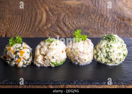 Four different dumplings on slate Stock Photo