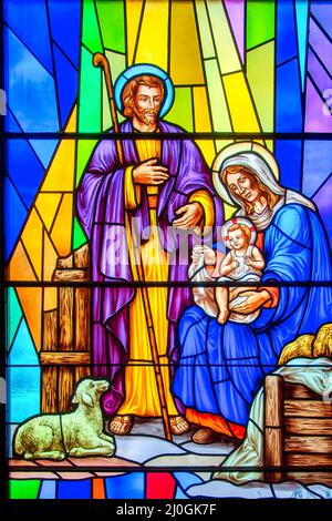 Nativity scene stained-glass window with Christian religious symbols seen in the Annunciation of the Blessed Virgin Mary Catholic Church. Mary, Joseph