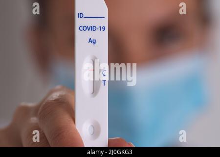 Closeup of woman showing express covid test with negative coronavirus result Stock Photo
