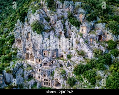 High angle drone aerial view of ancient greek rock cut tombs carved into cliffside in Myra (Demre Stock Photo