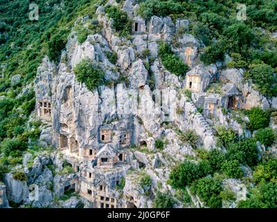 High angle drone aerial view of ancient greek rock cut tombs carved into cliffside in Myra (Demre Stock Photo