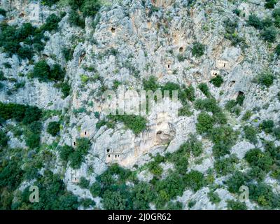 High angle drone aerial view of ancient greek rock cut tombs carved into cliffside in Myra (Demre Stock Photo