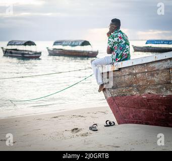Young black man sitting on boat taking selfie Stock Photo