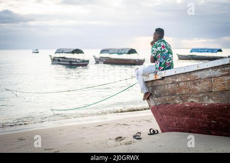 Young black man sitting on boat taking selfie Stock Photo