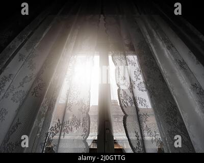 Sunlight coming through a window with lace curtains Stock Photo