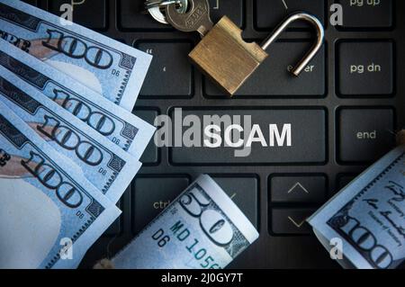 Scam text on red laptop tab with locker and bank notes background. Online security concept Stock Photo