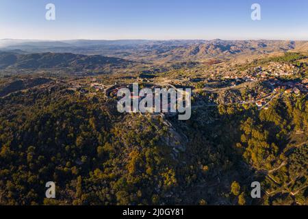 Drone aerial panorama of historic village of Sortelha with castle and with turbines on natural landscape, in Portugal Stock Photo