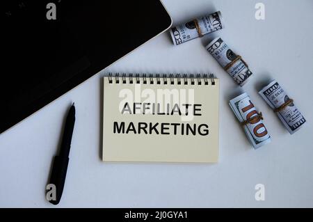 Affiliate marketing text on notepad with money and laptop background. Online business concept Stock Photo