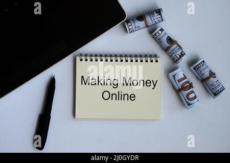 Making money online text on notepad with money and laptop background. Online business concept Stock Photo