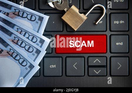 Scam text on red laptop tab with locker and bank notes background. Online security concept Stock Photo