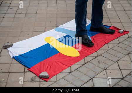 Madrid, Spain. 19th Mar, 2022. A man steps on a Russian flag during a protest in front of the Russian embassy. People gathered to protest against the Russian invasion of Ukraine demanding the end of war. Credit: Marcos del Mazo/Alamy Live News Stock Photo