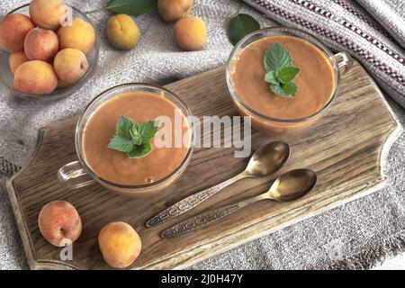 Apricot smoothie with yogurt and mint petals. Stock Photo
