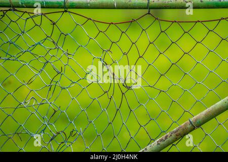 Broken mesh wire fence in the field Stock Photo