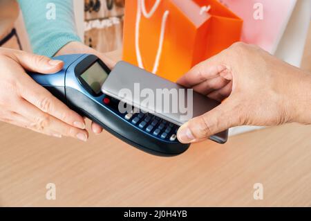 Closeup shot of a man paying using NFC technology in a clothing store Stock Photo