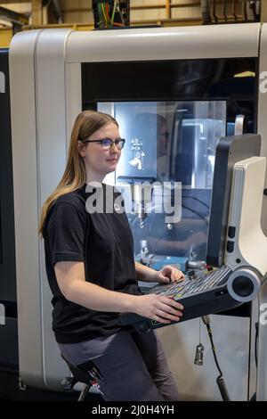 Oberhausen, North Rhine-Westphalia, Germany - Apprentice woman in metal trades. Trainee machinist at a CNC machine tool in the MAN training center. MA Stock Photo
