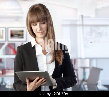 Happy white young businesswoman working with large business tablet. Woman in architect office. Stock Photo