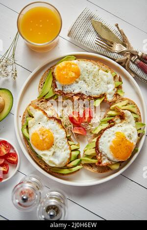 Delicious healthy breakfast with sliced avocado sandwiches with fried egg Stock Photo