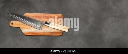 Traditional Japanese gyuto chief knife on a cutting board. Concrete background banner Stock Photo