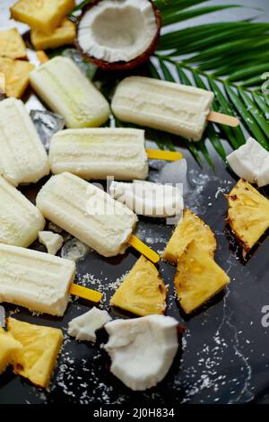 Summer popsicles on stick. Pinacolada flavour. Made with pineapple, cocount milk, rum. Vegan snack Stock Photo