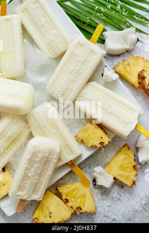 Homemade vegan popsicles made with coconut milk and pineapple. Delicious healthy summer snack Stock Photo