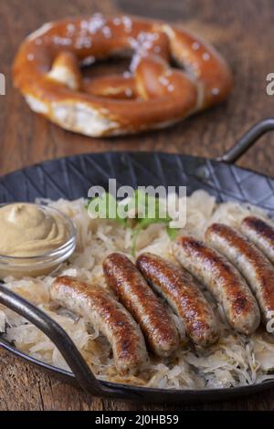 Grilled Nuremberger bratwurst with sauerkraut Stock Photo