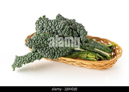 Italian black kale or Tuscan kale or lacinato or dinosaur kale into wicker basket isolated on white Stock Photo