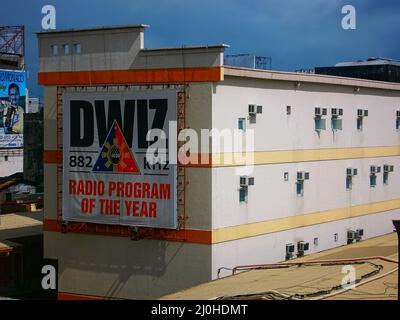 An advertising billboard for the DWIZ 882 radio station on side of building in metro manila Stock Photo