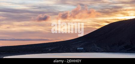 Montana Roja, Red mountain, silhouetted at dawn, sunrise from the beach at La Tejita, Tenerife, Canary Islands, Spain Stock Photo