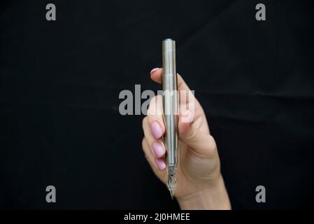 Silver microblading pen for eyebrow on black background Stock Photo
