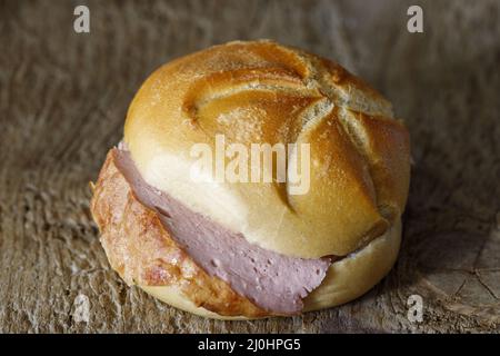 Bavarian liver cheese roll on dark wood Stock Photo