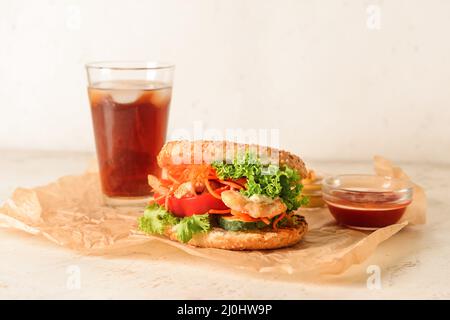 Fresh doner kebab in bun with sauce and glass of cola drink on light background Stock Photo