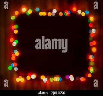Blurred christmas lights frame on dark background Stock Photo