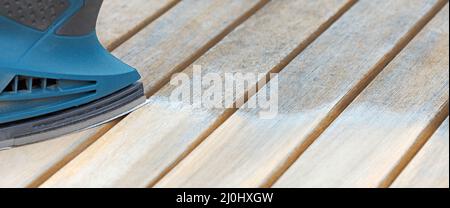 Sand down wooden furniture with a sanding machine in banner format Stock Photo