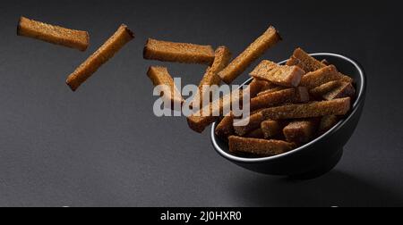 Falling rye croutons on black background Stock Photo