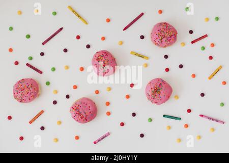 holiday, birthday party composition with colorful pink glazed donuts on white. Stock Photo