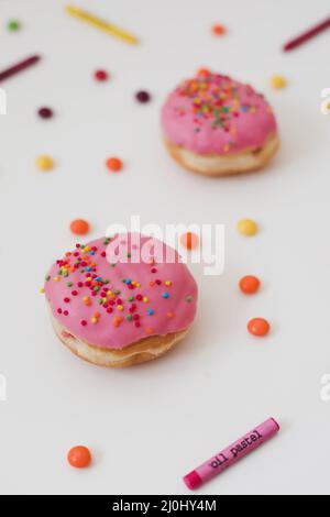 holiday, birthday party composition with colorful pink glazed donuts on white. Stock Photo