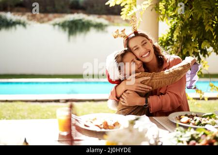 Family is what makes Christmas so special. Cropped shot of a girl girl and her mother enjoying Christmas lunch together. Stock Photo