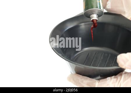 Gloved hands preparing organic hair dye at home. Close up shot of making organic hair dye for men, male, women and female. Stock Photo