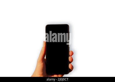 Man hand holding smartphone with empty black screen close up isolated on white background. Blank copy space for ad or advertisement texts. Stock Photo