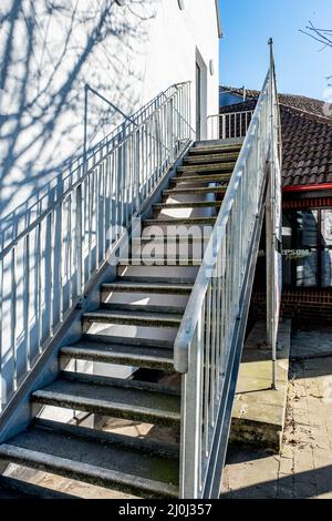 Epsom Surrey London UK, March 19 2022, Modern Outside Access Staircase With Metal Handrails Casting Shadow On A White Building Wall Stock Photo